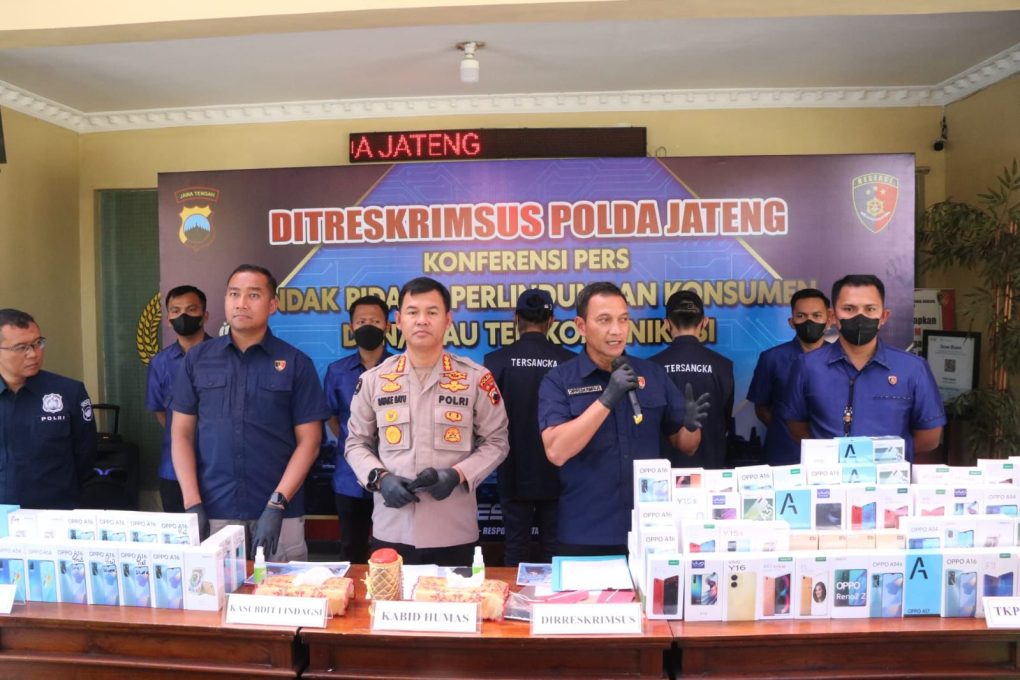 Polisi menunjukkan HP yang disita serta pelaku yang diamankan.
