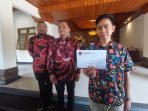 Wali Kota Solo, Gibran Rakabuming Raka menunjukkan undangan apel siaga yang diantar Sekretaris DPD PDIP Jateng, Sumantono di Balai Kota Solo, Rabu 23 Agustus 2023.