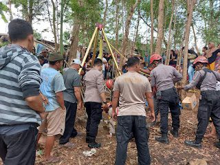 Petugas mengevakuasi seorang kakek yang ditemukan tewas tercebur di dalam sumur.