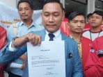 Kuasa hukum pelapor, Argo Triyunanto Nugroho beserta kader PSI Solo menunjukkan tanda terima pelaporan kasus dugaan penyelewengan dana banpol 2019-2022. (Foto: Putri Sejati)