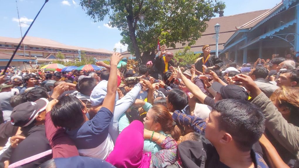 Warga memperebutkan gunungan dalam Grebeg Mulud yang digear yang digelar di halaman Masjid Agung Keraton Surakarta Hadiningrat, Senin 16 September 2024. (Foto: Putri Sejati)
