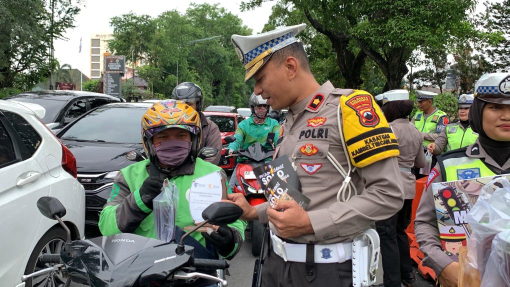 Jajaran Satlantas Polresta Solo membagikan es cendol dawet serta sejumlah suvernir kepada pengguna jalan yang dinilai tertib berlalu lintas yang sedang melintas di Jalan Slamet Riyadi, tepatnya di depan Mapolresta Solo, Selasa 31/ Desember 2024. (Foto: Putri Sejati)