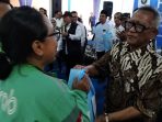 Pengusaha Restoran Wong Solo Grup, Puspo Wardoyo (kanan) membagikan paket sembako kepada pengemudi ojol di halaman Gudang Bulog, Ngabeyan, Kecamatan Kartasura, Kabupaten Sukoharjo, Jawa Tengah, Jumat 2 Januari 2026. (Foto: dok Red)