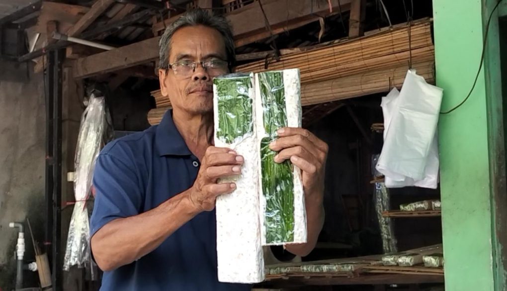 Produsen tempe, Subandi, menunjukkan perbandingan ukuran tempe yang sudah dipangkas dampak dari naiknya harga bahan baku kedelai impor asal Amerika Serikat dan naiknya harga plastik di rumah produksinya di Desa Jembungan, Kecamatan Banyudono, Kabupaten Boyolali, Jawa Tengah, Selasa 7 April 2026. (Foto: Agatha Janendra)