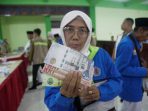 Jemaah Calon Haji Kloter 6 asal Brebes menunjukkan living cost atau uang saku yang didistribusikan BPKH di Embarkasi Solo, Jawa Tengah, Jumat 24 April 2026. (Foto: dok. BPKH)