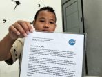 Siswa kelas 6 SD Negeri 3 Genengsari, Ibrahim Al Abrar menunjukkan surat tanda penghargaan yang diberikan oleh Nasa atas keberhasilannya melaporkan celah keamanan domain publik milik Nasa di rumahnya di Desa Genengsari, Kecamatan Kemusu, Kabupaten Boyolali, Jawa Tengah, Sabtu, 18 Juli 2026. (Foto: Agatha Janendra) 18/07/2026.