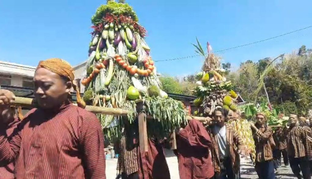 Warga pesisir Pantai Nampu sekaligus peserta kirab mengusung gunungan saat tradisi sedekah bumi di Desa Gunturharjo, Kecamatan Paranggupito, Kabupaten Wonogiri, Jawa Tengah. (Foto: Agatha Janendra)