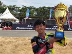 Pebalap cilik Muhammad Ali Imamudin mengangkat piala seusai sapu bersih juara satu pada Kejurnas FIM MotoMini Indonesia Series Boyolali 2026 di Sirkuit Boyolali, Jawa Tengah, Minggu Sore. (Foto: Agatha Janendra)