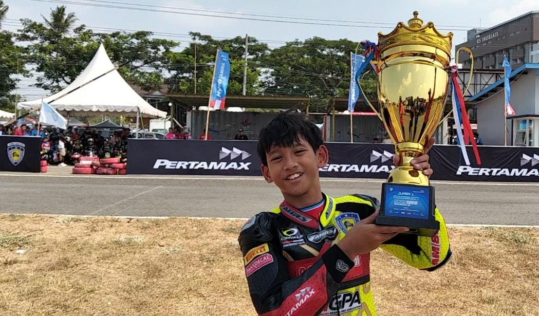 Pebalap cilik Muhammad Ali Imamudin mengangkat piala seusai sapu bersih juara satu pada Kejurnas FIM MotoMini Indonesia Series Boyolali 2026 di Sirkuit Boyolali, Jawa Tengah, Minggu Sore. (Foto: Agatha Janendra)